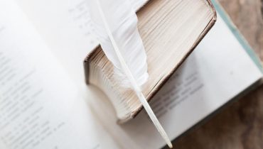 Image Showing A Feather Placed On An Antique haiku Poem Book