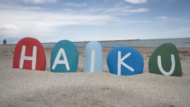 Word Haiku Made By Color Stones In A Beach