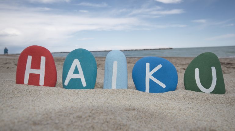 Word Haiku Made By Color Stones In A Beach